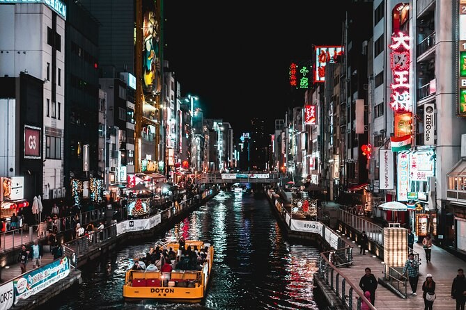 Sightseeing boats on the Dotonbori canal below the signboards
