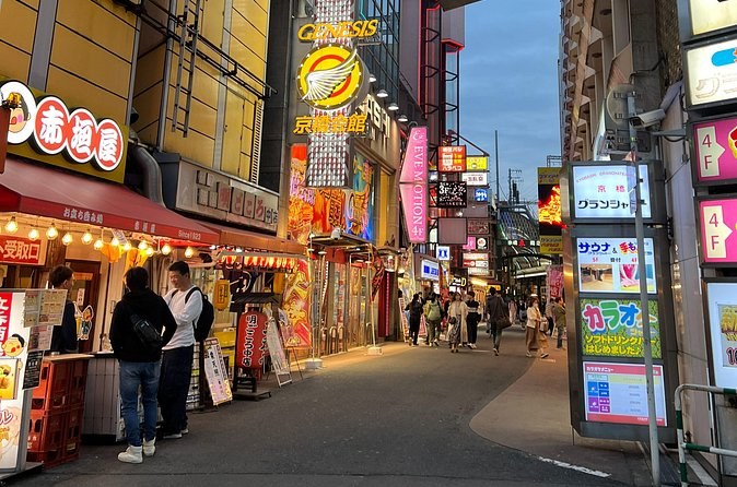 Dotonbori's shopfronts coming on at dusk