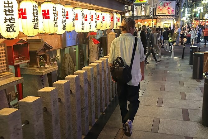A row of white lanterns marking the entrance to Hozenji Yokocho