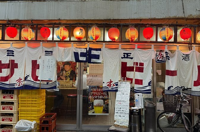 Red lanterns and noren curtains outside an Osaka izakaya