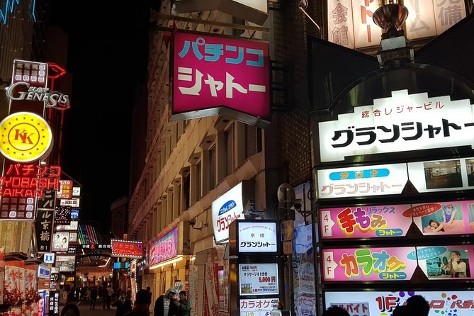 Neon arcade and pachinko signs above a Namba street at night