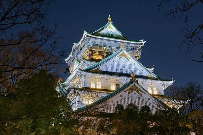 Osaka Castle floodlit against a dusk sky